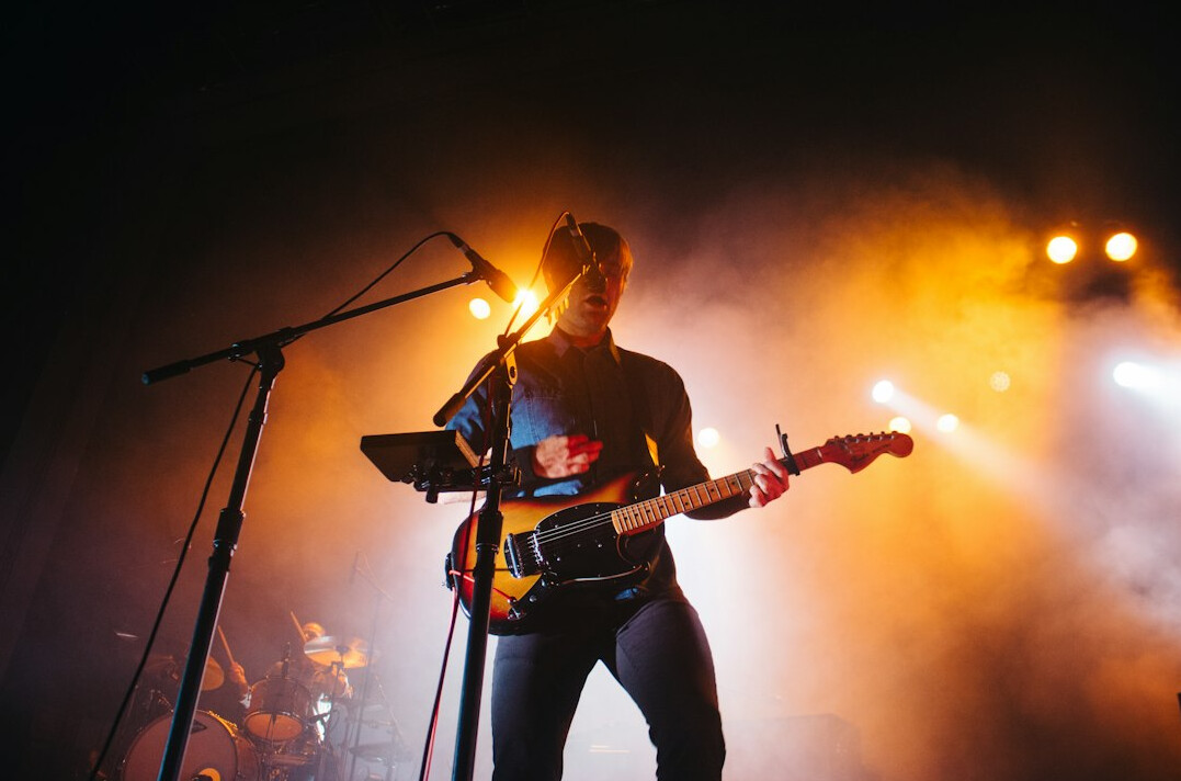 Musician performing on stage with guitar