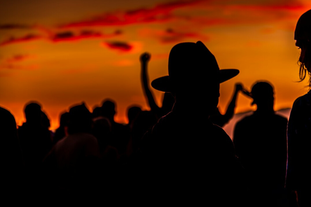 Crowd at an open-air music festival at sunset